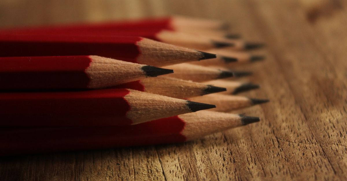 Lápices de madera alineados junto a una goma de borrar sobre un escritorio claro